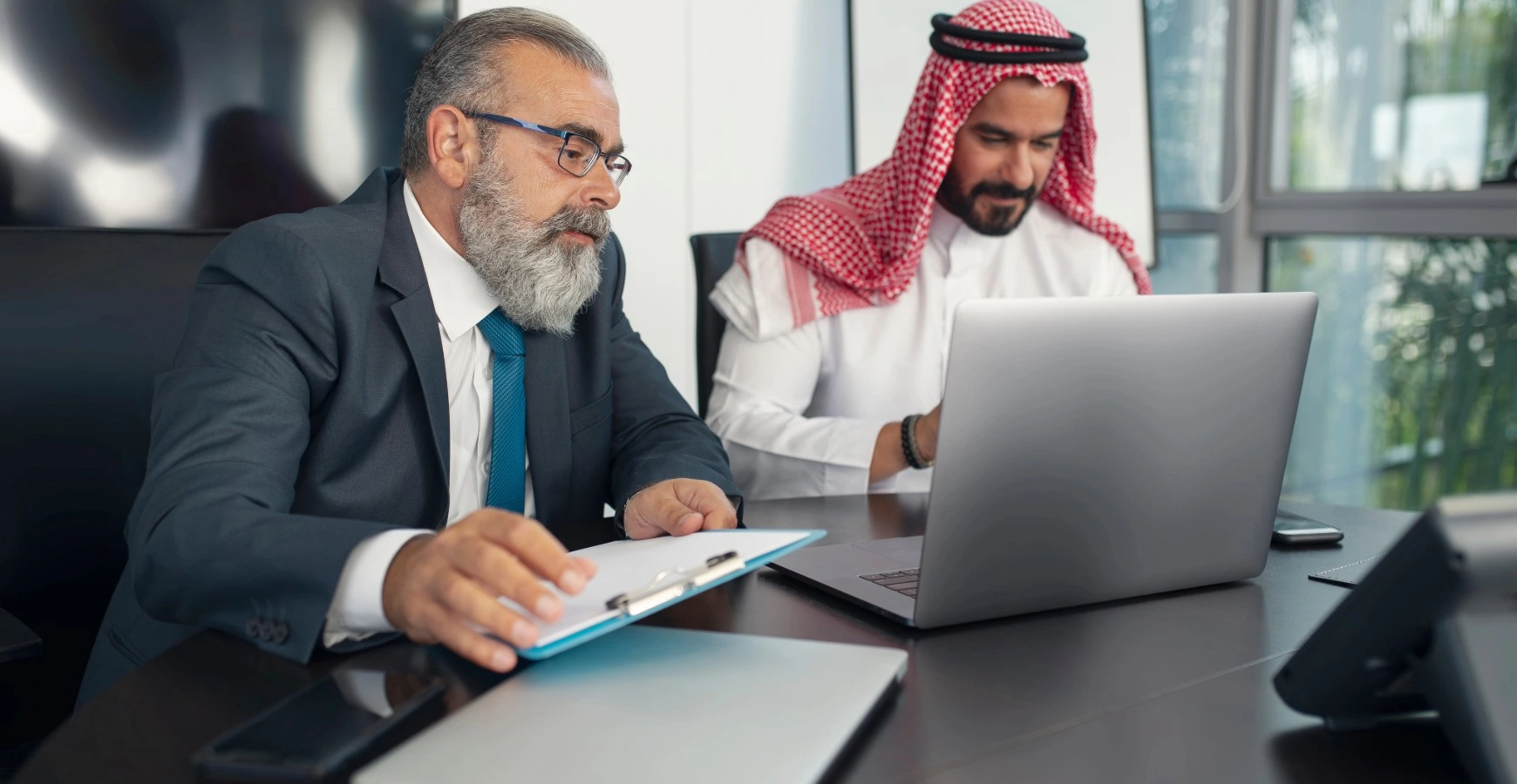Dubai mainland business setup consultant reviewing documents with Emirati client