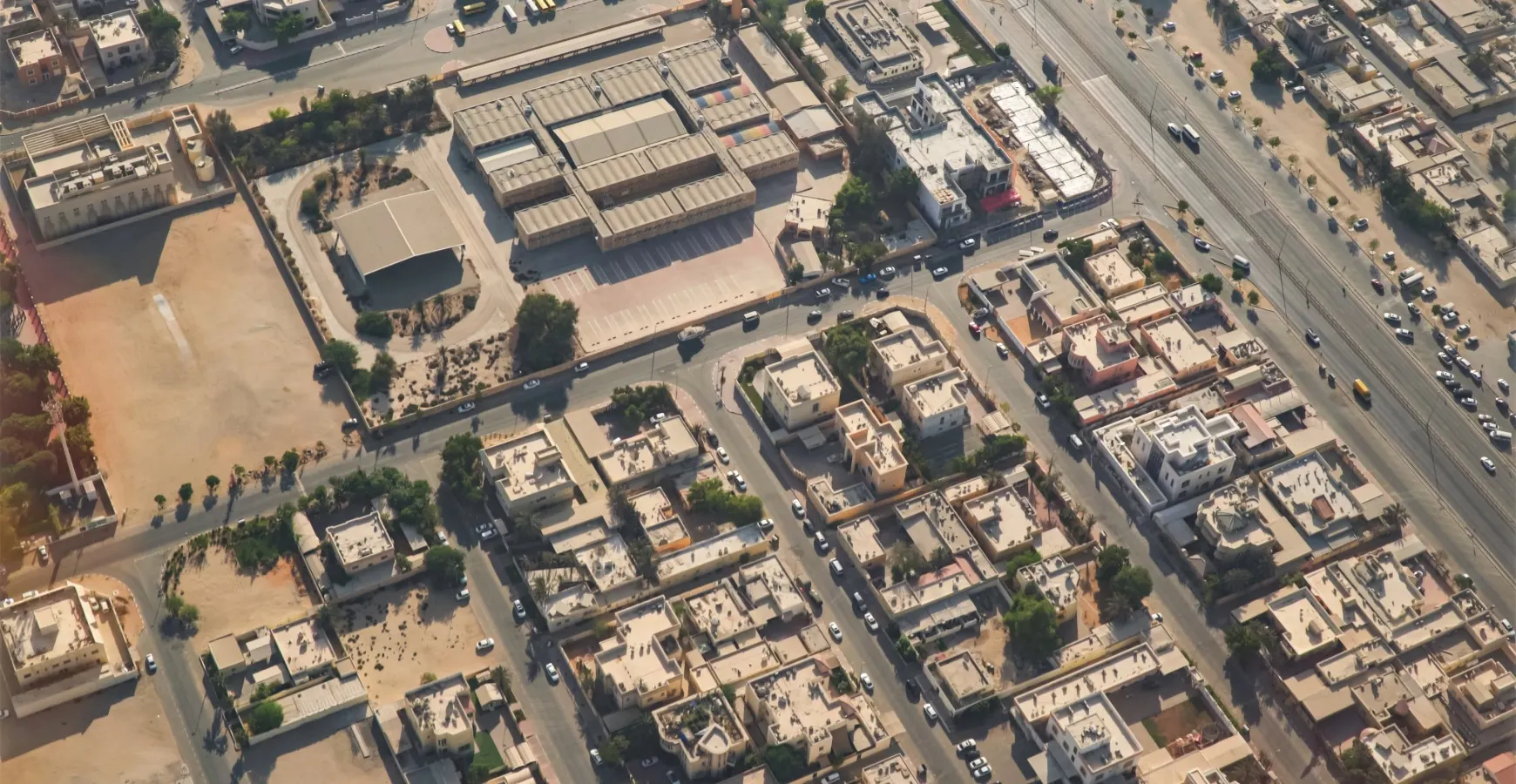An overhead aerial view of a structured commercial and industrial district showing warehouses, office buildings, roads, and logistics infrastructure within JAFZA.