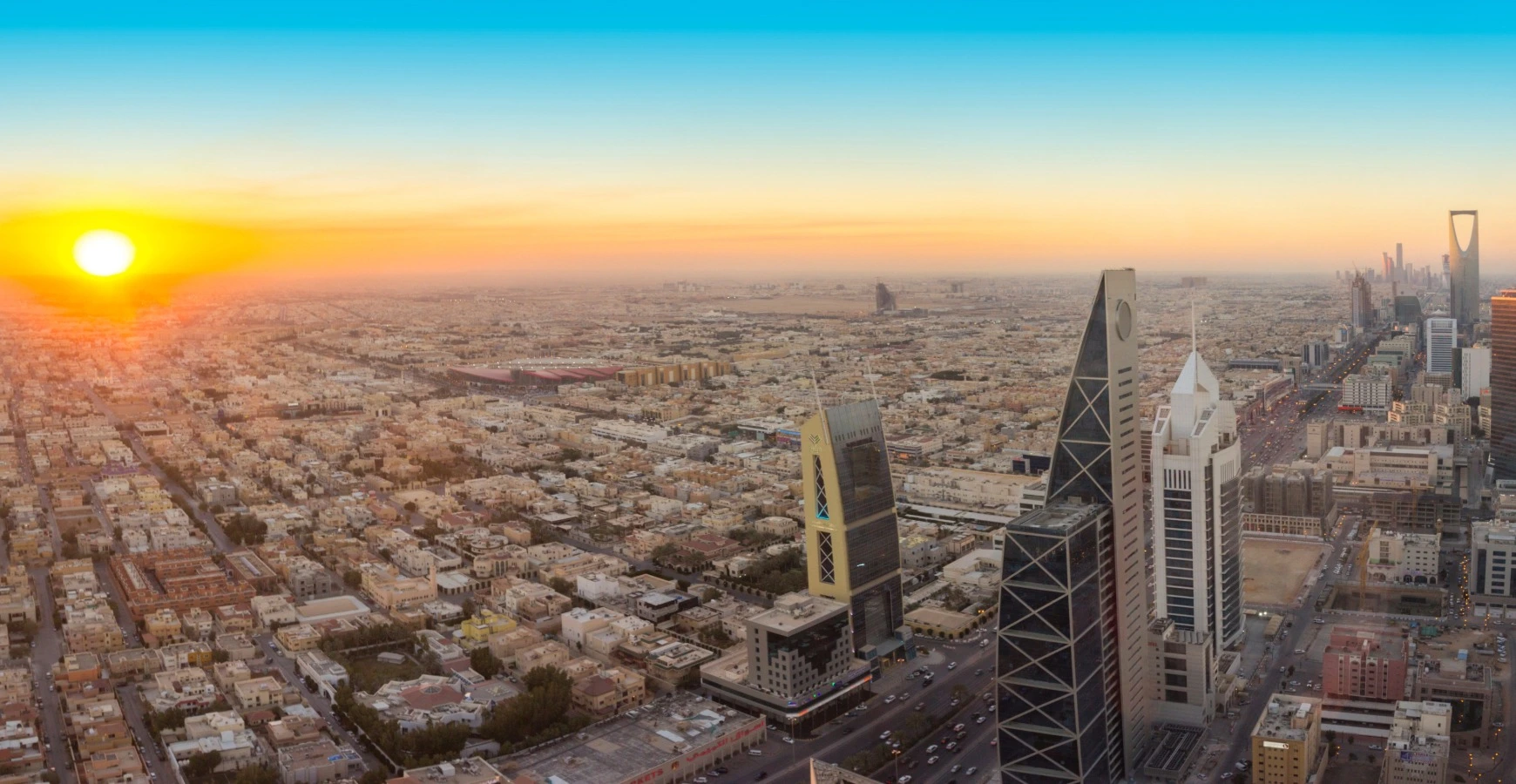 Aerial view of the modern Riyadh cityscape and skyscrapers at sunrise, representing emerging market expansion through Saudi Arabia business setup.